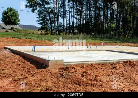 Concrete slab foundation (slab-on-grade) built from formwork with plumbing prep for residential home Stock Photo