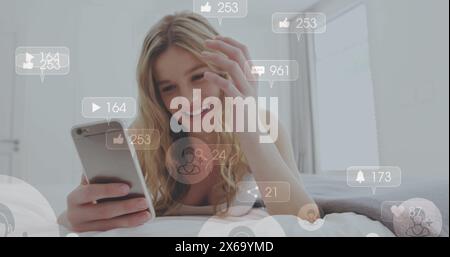 Image of media icons over happy caucasian woman using smartphone Stock Photo