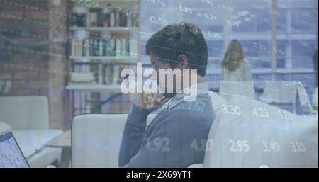 Image of stock market data processing over thoughtful caucasian man using laptop at office Stock Photo