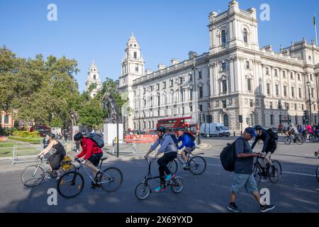 Bike riding London, cyclists ride bicycles in Parliament Square Westminster Central London on blue sky sunny autumn Monday day,England,UK,2023 Stock Photo
