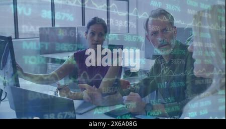 Image of trading board over diverse coworkers sharing ideas on desktop in office Stock Photo