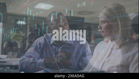 Image of graphs, loading circles and trading board over diverse coworkers discussing reports Stock Photo