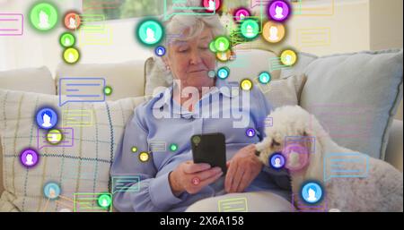 Image of media icons over happy senior caucasian woman with dog Stock Photo