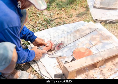 Worker use cutting machine cut a white tile ceramic for assembly in construction site. Stock Photo