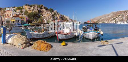 Panoramic view of colorful fishing harbor lined with traditional boats on Symi Island, Greece Stock Photo