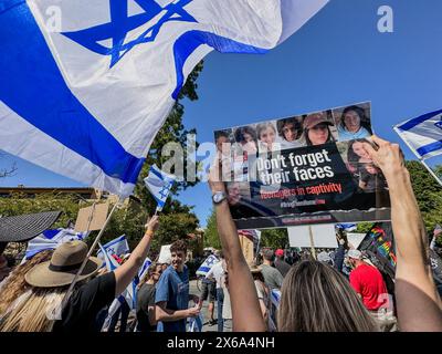 Palo Alto, California, U.S.A. 12th May, 2024. Israel and American flags flying and a Jewish woman holding a sign, 'Don't forget their faces: teenagers in captivity'', and as Hundreds of Jews are joined by Hindus, Muslims, Chinese and other allies at a Counter-Rally at Stanford University on Israel Independence Day and Mother's Day at an Interfaith rally organized by a Jewish student group. This was at the far end of White Square, where Pro-Palestine Protestors have set up a tent encampment and were holding a rally where they called for 'Intifada'' against Israel, made fun of the Jews Stock Photo