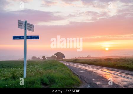 Sunrise alonh a cotswold road near Shipton-under-Wychwood. Cotswolds, Oxfordshire, England Stock Photo