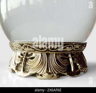 A fortune teller crystal ball with an ornate decorated brass base in an isolated white studio background - 3D render Stock Photo