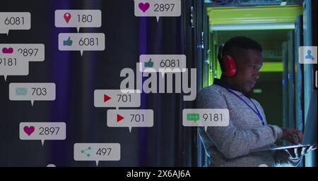 Image of icons and numbers over african american male it technician by computer servers Stock Photo