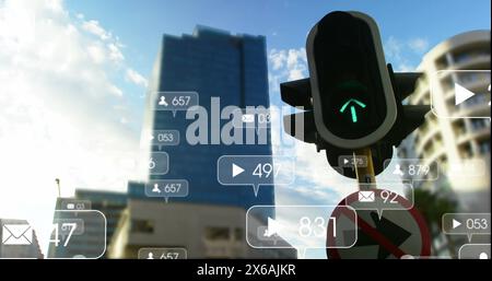 Image of notification icons with numbers over traffic signal changing lights in city Stock Photo
