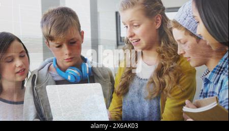 Image of data processing over group of diverse students using laptop at school Stock Photo
