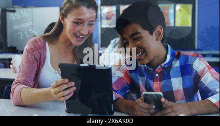 Image of data processing over diverse girl and boy using digital tablet together at school Stock Photo