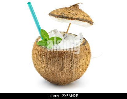 Exotic iced cocktail in coconut shell garnished with mint and straw isolated on white background. Summer vibes. Stock Photo