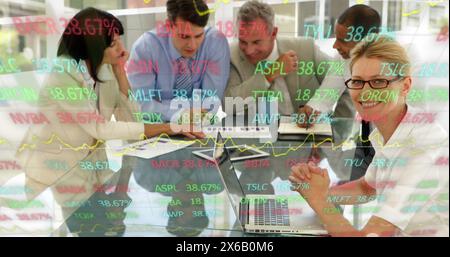 Image of trading board over diverse coworkers discussing reports in meeting at office Stock Photo