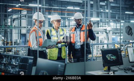 Young Diverse Team of Automotive Engineers Working in Office at Car Factory. Industrial Designer Talks About Electric Engine Parts with Colleagues, Discussing Different Technological Applications. Stock Photo