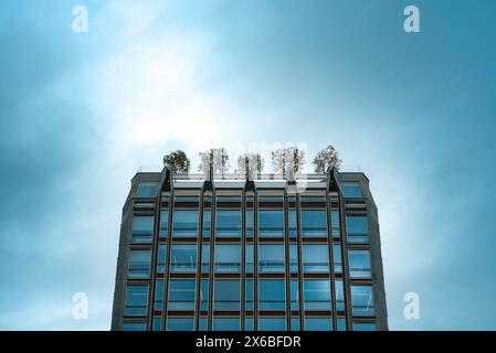 Contemporary office building with trees on top Stock Photo