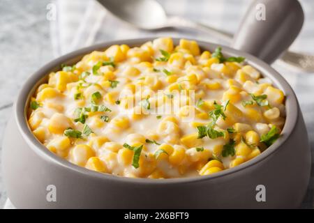 Sweet corn with rich cream, butter, parmesan cheese closeup on the bowl on the table. Horizontal Stock Photo