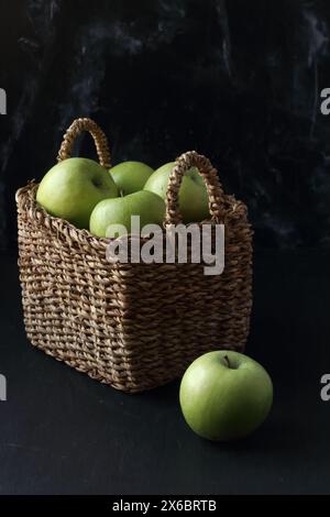 Green apples in a basket on a black background Stock Photo