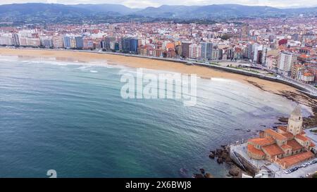 Aerial view of San Pedro Church, the waters of the Atlantic Ocean, Playa de San Lorenzo beach, the promenade, and the city. Gijón, Asturias, Spain. Stock Photo