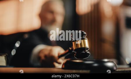 Court of Law and Justice Trial Session: Imparcial Honorable Judge Pronouncing Sentence, striking Gavel. Focus on Mallet, Hammer. Cinematic Shot of Dramatic Not Guilty Verdict. Close-up Shot. Stock Photo