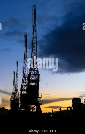 Cranes in The dock at Harbourside area in Bristol at sunset Stock Photo