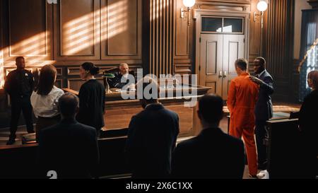 Court of Law and Justice Trial: Imparcial Honorable Judge Pronouncing Sentence, Striking Gavel. Shot of Male Lawbreaker in Orange Robe Sentenced to Serve Time in Prison. Hearing Adjourned, Stock Photo