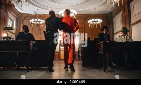 Cinematic Court of Law and Justice Trial Proceedings: Portrait of Accused Male Criminal in Orange Jumpsuit Led Away by Security Guard in Front of Jury. Convict Sentenced to Serve Jail Time. Stock Photo