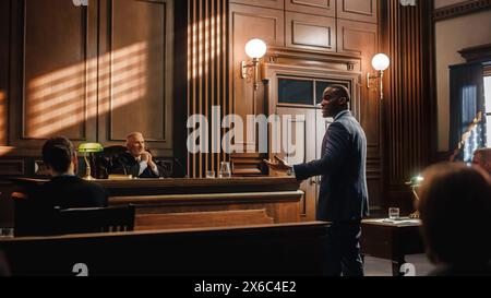 Court of Law, Trial in Session: Portrait of Charismatic Male Public Defender Making Touching, Passionate Speech to Judge and Jury. Attorney Lawyer Protecting Client, Presenting Case for Justice. Stock Photo