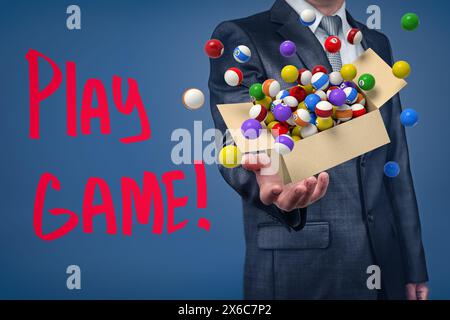 Businessman holding cardboard box filled with colorful pool and billiard balls Stock Photo