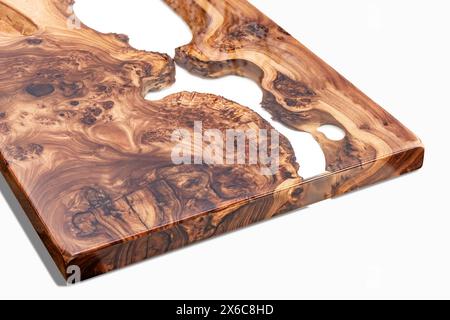 Live edge elm burl slab table top with central epoxy resin river on white background, combining natural wood with a synthetic material Stock Photo