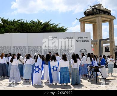 Latrun, Israel. 14th May, 2024. Teens wear the Israeli national flag at a memorial in the Latrun Tank Museum on Israel's 76th Independence Day on Tuesday, May14, 2024. Independence Day celebrations are muted with the ongoing Israel-Hamas war. Photo by Debbie Hill/ Credit: UPI/Alamy Live News Stock Photo