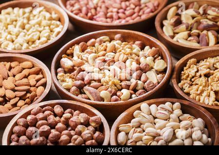 bowls of various mixed nuts on wooden table Stock Photo