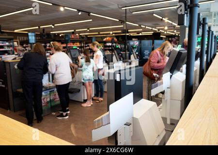 Customers scanning shopping groceries at selr checkout tills M&S store food hall interior Marks and Spencer supermarket Wales UK KATHY DEWITT Stock Photo