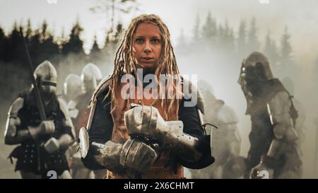 Epic Battlefield: Portrait of Powerful Female Leader Warrior Holding Sword, Ready for Battle. Woman Knight General in Dark Age Medieval War against Invasion. Dramatic, Cinematic, Historic Reenactment Stock Photo