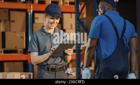Female Manager Using Tablet Computer To Check Inventory. Warehouse Retail Center with Cardboard boxes, e-Commerce Online Orders, Food. Frontline Hero. Stock Photo
