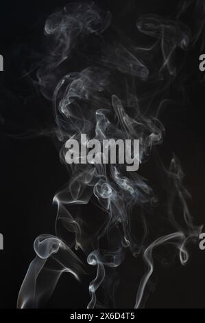 Fluffy curly white smoke lines isolated on black background Stock Photo