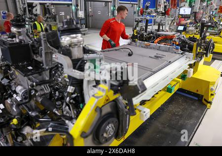06 May 2024, Saxony, Leipzig: A Porsche employee wires the battery and chassis on an all-electric Porsche Macan at the Leipzig plant. The official launch of electromobility in Leipzig was celebrated on the same day. The sports car manufacturer has invested around 600 million euros in the expansion of the plant. The new Macan is the second all-electric Porsche model. The Leipzig plant is designed for maximum flexibility in the future. Gasoline, hybrid and fully electric vehicles will run on a shared production line. Porsche aims to deliver more than 80 percent of new vehicles with purely electr Stock Photo