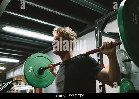 Low angle shot of a handsome athletic man doing barbell workout at crossfit gym Stock Photo