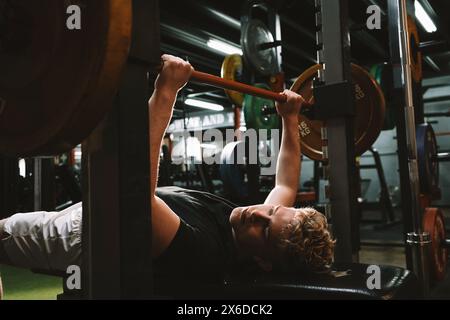 Strong athletic man doing bench press at the gym Stock Photo