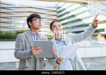 Young Business Professionals Engaged in Outdoor Discussion With Digital Tablet Stock Photo