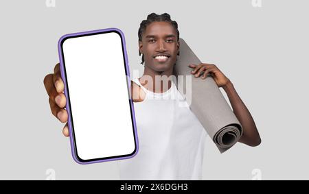 Black Man Holding Yoga Mat and Cell Phone Stock Photo