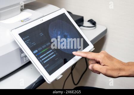 Technician fingers working the touch screen controls of the eye doctor imaging machine. Stock Photo