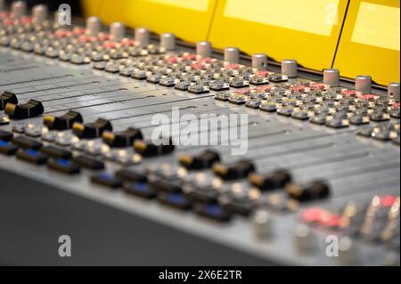 Close-up view of professional audio mixer control panel with knobs and switches Stock Photo
