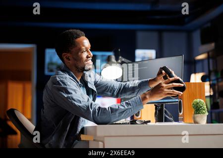 IT specialist coding html script and listens to music on headset, working as a system engineer to create technical support protection. Programmer working from home on terminal window. Stock Photo