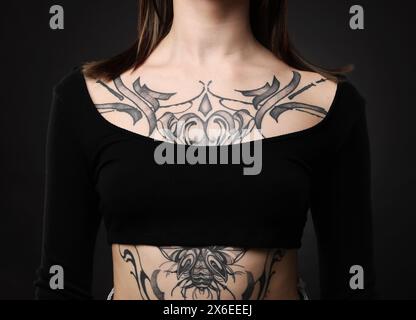 Woman with cool tattoos on black background, closeup Stock Photo