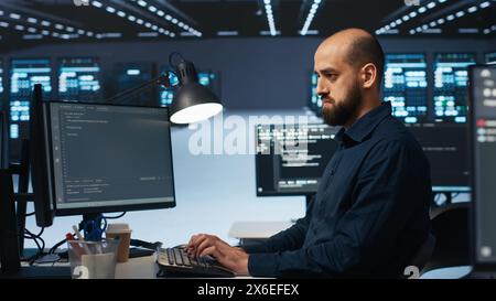 Software developer programming in high tech facility with server rows providing computing resources for different workloads. IT expert reviewing data center supercomputers Stock Photo