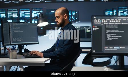 Computer scientist programming in high tech facility with server rows providing computing resources for different workloads. IT programmer overseeing supercomputers tasked with solving data operations Stock Photo