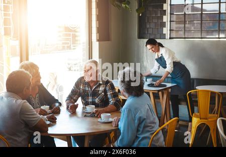 Senior, people and group relax at coffee shop with discussion of life extension drugs in retirement. Elderly, friends and talk at cafe with healthcare Stock Photo