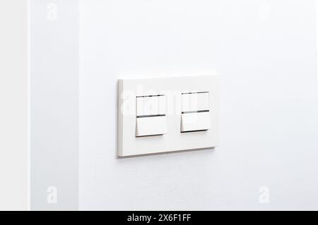 White light switch and faceplate on white wall Stock Photo