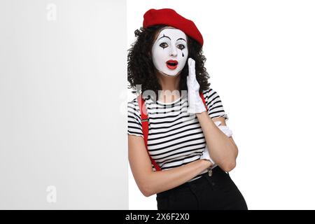 Funny mime with blank poster posing on white background Stock Photo